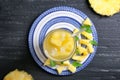 Glass of tasty fresh pineapple juice on wooden table, top view Royalty Free Stock Photo