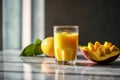 Glass of mango banana smoothie for breakfast on sunny morning in the kitchen