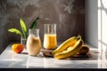 Glass of mango banana smoothie for breakfast on sunny morning in the kitchen
