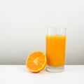 The glass of tasty pure orange juice and fresh orange half Royalty Free Stock Photo