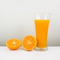 The glass of tasty pure orange juice and fresh orange half Royalty Free Stock Photo