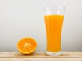 The glass of tasty pure orange juice and fresh orange half on wooden tray Royalty Free Stock Photo