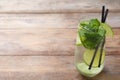 Glass of tasty refreshing cocktail with lime and mint on wooden table Royalty Free Stock Photo