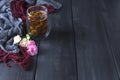 A glass of tea on a black wooden background and flowers. Copy cpace