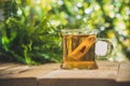 Glass tea cup with bag on wooden table in front of floral spring garden nature outdoor with bokeh Royalty Free Stock Photo