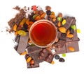 Glass tea cup and dried fruits and chocolate piles with filberts. Dessert food photo