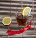 Glass of tea and nearby lemon, on a rug Royalty Free Stock Photo