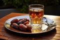 Glass of Tea and Nuts on Plate, Refreshing Beverage and a Nutty Snack, Glass of water and dry dates on saucer ready to eat for