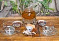 Glass tea pot with cups of marmalade and crystalized fruits on wooden table Royalty Free Stock Photo