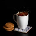 Glass with tea pouring with liquid with splashes and drops of water. Brewing tea concept. Cup pouring with water or tea Royalty Free Stock Photo