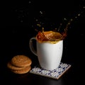 Glass with tea pouring with liquid with splashes and drops of water. Brewing tea concept. Cup pouring with water or tea Royalty Free Stock Photo