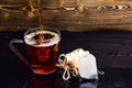 Glass with tea pouring with liquid with splashes and drops of water. Brewing tea concept. Cup pouring with water or tea Royalty Free Stock Photo