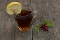 Glass of tea, segment of a lemon and branch of currant