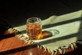 a glass of tea on the tablecloth between the shadow lines of the house windows Royalty Free Stock Photo