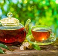 Glass teapot with brewed tea is on the table on a sunny summer day Royalty Free Stock Photo