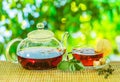 Glass teapot with brewed tea is on the table on a sunny summer day Royalty Free Stock Photo