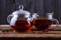 Glass teapot and cup with hot tea on wooden background Royalty Free Stock Photo