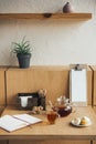 glass teapot with cup of tea, macarons and open notebook on table Royalty Free Stock Photo