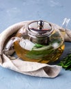 Glass Teapot with Herbal Tea Hot and Tasty Tea with Mint Sage and Rosemary Blue Background Linen Napkin