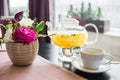 Glass teapot with hot pineapple tea with pineapple slices in a cafe. A cup of fragrant yellow tea, a glass teapot and beautiful pi Royalty Free Stock Photo