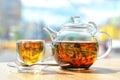 A glass teapot with tea and a cup with tea stand on the table Royalty Free Stock Photo