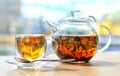 A  glass teapot with tea and a glass cup with tea stand on the table ON A LIGHT BACKGROUND Royalty Free Stock Photo