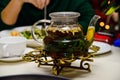 Glass teaspot with mint tea and cedar nuts on the table