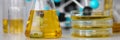 Glass test tubes with yellow viscous liquid stand on table in chemical laboratory closeup Royalty Free Stock Photo