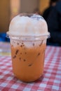 A glass of Thai iced milk tea with ice in a plastic cup Royalty Free Stock Photo