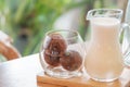 glass of three iced coffee balls on wood tray served with milk, homemade latte refreshment in cafe background