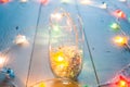 Glass and tinsel, the lights on the wooden table, Royalty Free Stock Photo