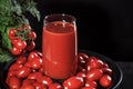 Glass of tomato juice covered with cherry tomatoes comes from a natural tomato bush, conceptual image Royalty Free Stock Photo