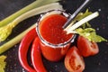 1 glass of tomato juice with fresh tomatoes, celery, salt , cocktail tubes , chili pepper on a black