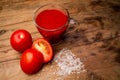 Glass with tomato juice and ripe tomatoes on a wooden table Royalty Free Stock Photo