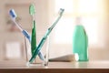 Glass with toothbrushes on wood table in bathroom general composition Royalty Free Stock Photo