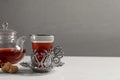 Glass of traditional Turkish tea in vintage holder, sugar and pot on white table. Space for text Royalty Free Stock Photo