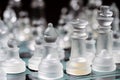 glass, transparent chess pieces on a checkerboard, selective focus, close-up, isolated on black Royalty Free Stock Photo