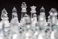 glass, transparent chess pieces on a checkerboard, selective focus, close-up, isolated on black Royalty Free Stock Photo