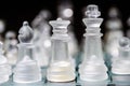 glass, transparent chess pieces on a checkerboard, selective focus, close-up, isolated on black Royalty Free Stock Photo