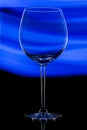 Glass transparent wine glass on abstract blue background Royalty Free Stock Photo