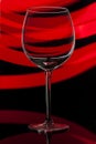 Glass transparent wine goblet on abstract glowing background