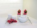 Glass tray with white teapot, cups and red grapes