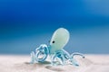 Glass tropical sea octopus on white beach sand