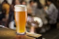 Glass of unfiltered beer stands on a table in a pub