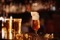 glass of unfiltered draft golden foam beer with on the bar counter