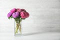 Glass vase with beautiful aster flowers on table against background. Space for text