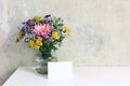 Glass vase with beautiful colorful bouquet of dahlia, tansies and aster flowers. Grunge old wall background. Feminine Royalty Free Stock Photo