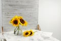 Glass vase with beautiful sunflowers and double-sided backdrop on table in photo studio Royalty Free Stock Photo