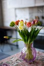 Glass vase with bouquet of beautiful tulips on brick wall background Royalty Free Stock Photo