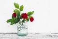 Glass vase with bouquet of roses on vintage table Royalty Free Stock Photo